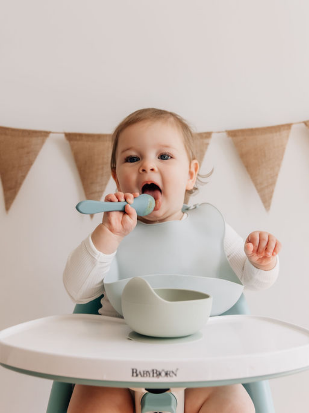 happy baby wearing duck egg blue silicone bib with suction bowl and silicone spoon